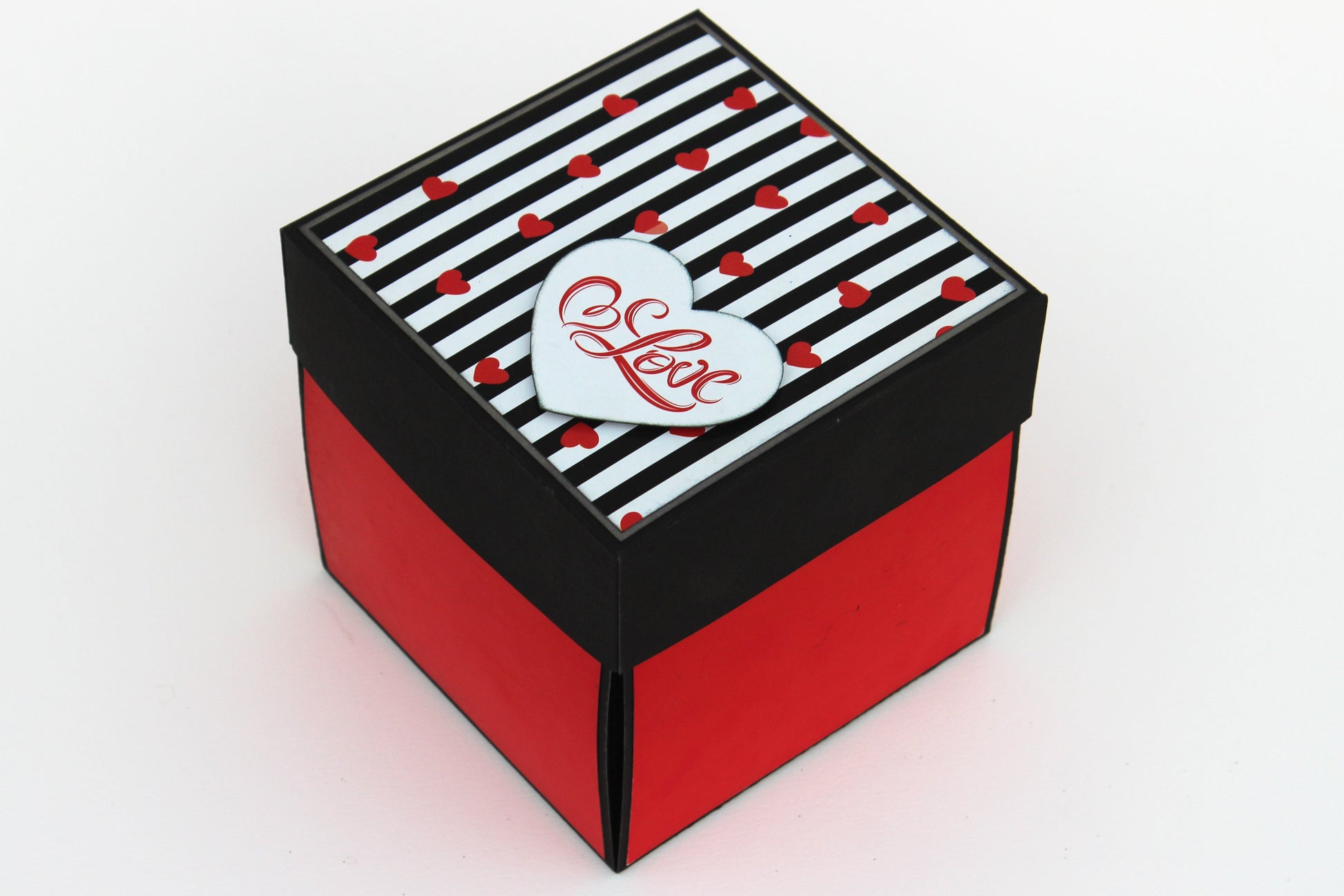 5 Star chocolate explosion box closed view with black and red striped lid and heart detail